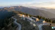 A scenic high-altitude scientific observatory surrounded by hills under a clear sky
