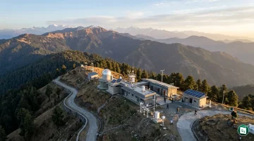 A scenic high-altitude scientific observatory surrounded by hills under a clear sky